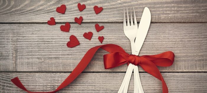 couverts attachés par un ruban rouge pour une table de Saint Valentin